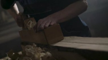 Tulumlu adam bir atölyede ahşap kiriş parlatma. 