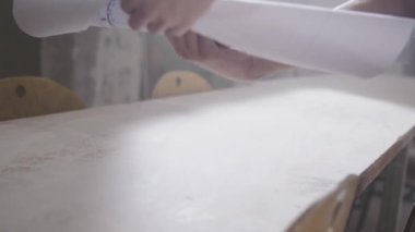 Adam inşaat harita masaya koyuyor. 