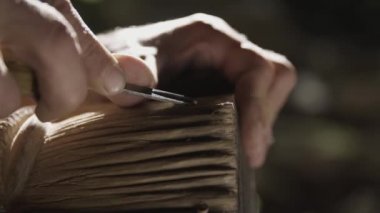 Yaşlı adam bir mağarada ahşap oyma.