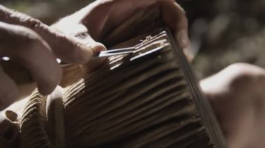 Yaşlı adam bir mağarada ahşap parlatma.