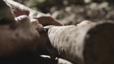 Yaşlı adam bir mağarada ahşap oyma. 