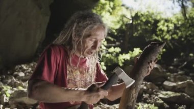 Yaşlı adam bir mağarada ahşap oyma. 