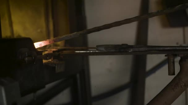 Le forgeron réchauffe le fer dans le feu . 