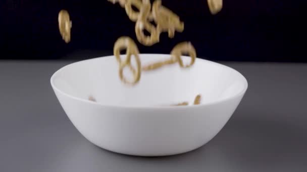 Pretzels are falling into a bowl.
