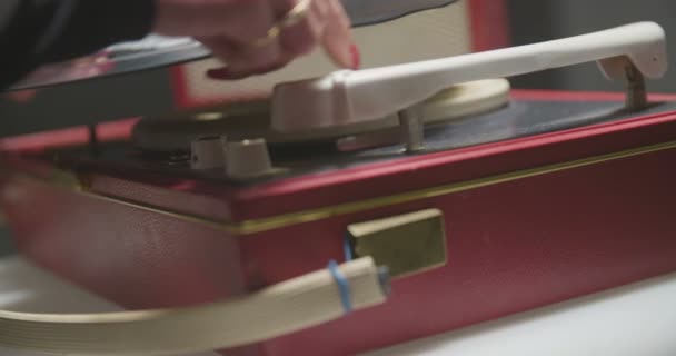 Femme met un record sur le gramophone rouge .