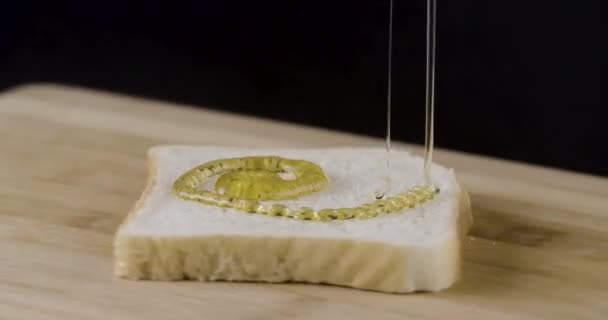 浇蜂蜜在烤面包 是纺纱 — 图库视频影像