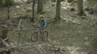 Yokuş aşağı dağ bisikleti binici bir ormanda.
