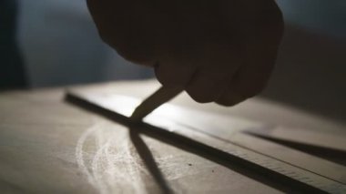 İnşaat işçisi bir cetvel kullanarak bir düz çizgi çizer