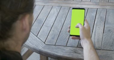 Adam yeşil ekran akıllı telefon tutarak