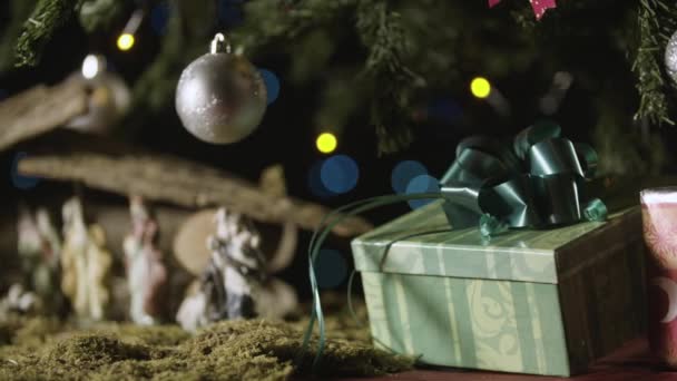 クリスマスのキリスト降誕のシーンとクリスマス ツリーの下のプレゼント — ストック動画