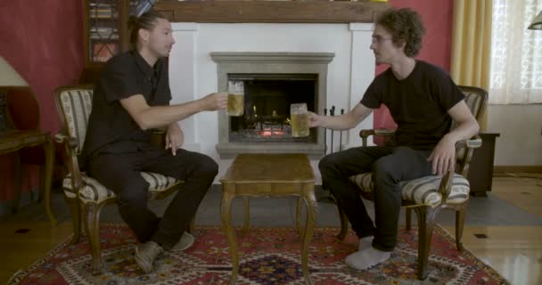 Dos Hombres Bebiendo Cerveza Frente Chimenea — Vídeos de Stock