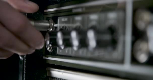 手插插在插孔电缆成吉他放大器和转动放大器旋钮 — 图库视频影像