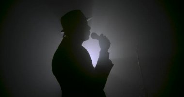 Bir mikrofon siluet tutan şarkıcı