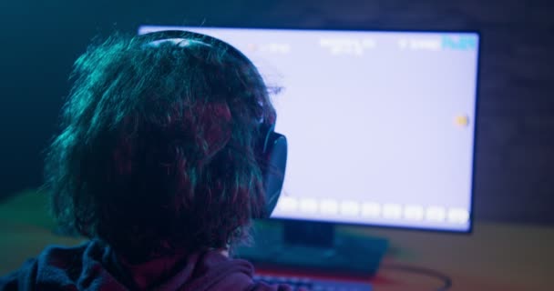 Gamer van terug met koptelefoon afspelen van een video game — Stockvideo