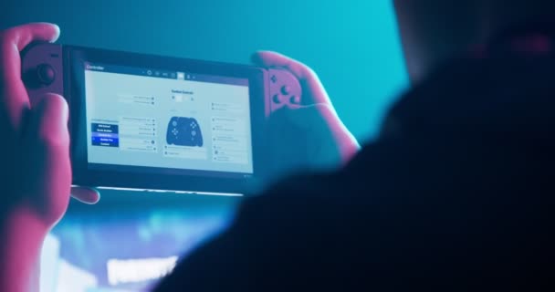 Геймер играет на консоли за своим персональным компьютером — стоковое видео