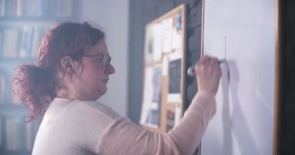 Creatieve vrouw is een grafiek tekenen op het whiteboard — Stockvideo