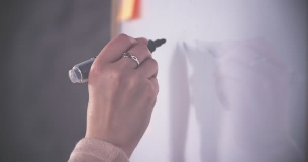 Close-up da mão de uma mulher escrevendo em um quadro branco — Vídeo de Stock