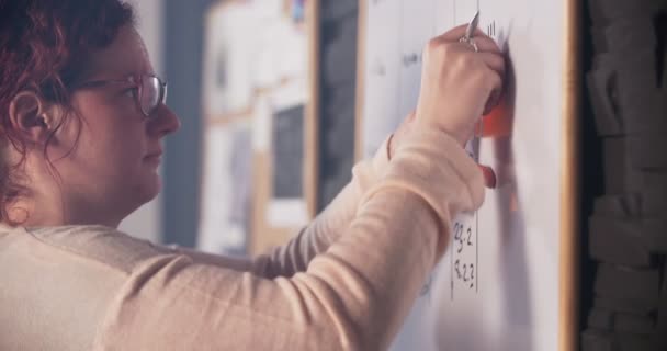 Creatieve vrouw steekt notities op whiteboard — Stockvideo