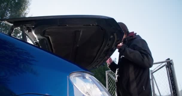 Mladý muž, kontrola pod kapotu svého auta — Stock video