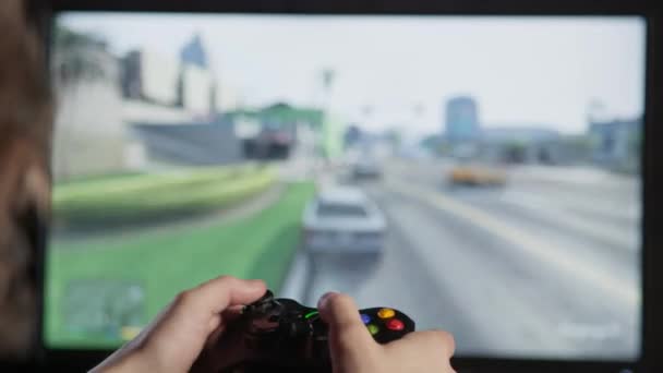 Boy speelt video games op een console met een controller — Stockvideo