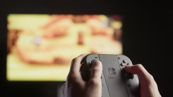 Jugar videojuegos en una consola de juegos con un controlador — Vídeo de stock