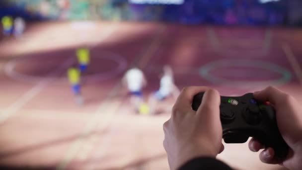 Jugar videojuegos con un controlador delante de un televisor — Vídeo de stock