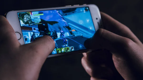 Ekranda popüler oyun ile elinde telefon tutma