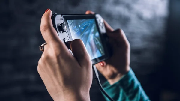 Vrouw hand bedrijf gamepad Rechtenvrije Stockfoto's