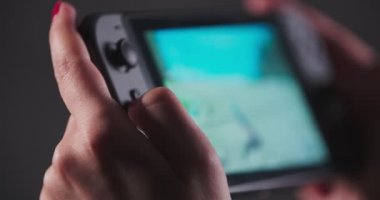 Kırmızı tırnaklar kız bir konsolda video oyunları oynuyor