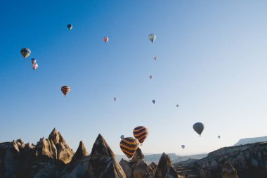 Göreme, Türkiye - 4 Nisan 2012: uçan Dağları üzerinde ve mavi gökyüzü ile renkli balonlar