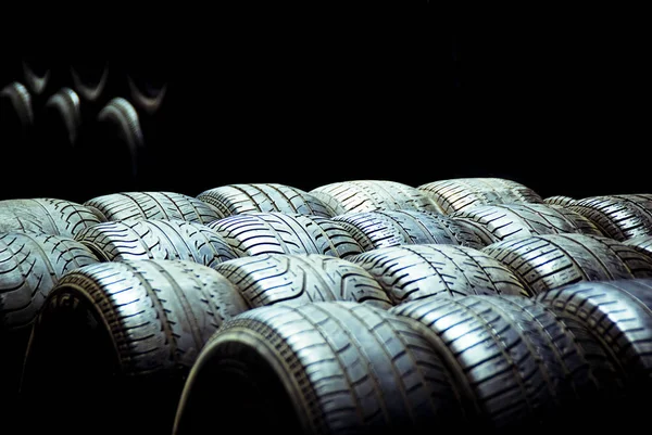 Old tires and racing wheels stacked in the sun