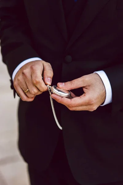Old pocket watch in the hands of a man