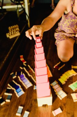 Çocuklar bir Montessori sınıfta pembe kule ile oyun