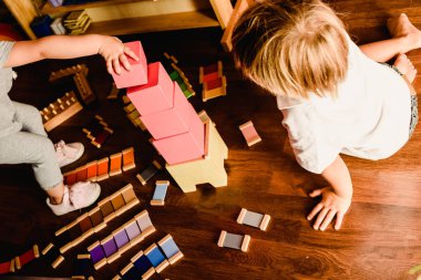 Çocuklar bir Montessori sınıfta pembe kule ile oyun