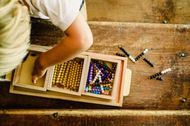 Montessori sınıfta saymak öğrenmek için eğitim materyalleri işleme bir çocuğun elleri.