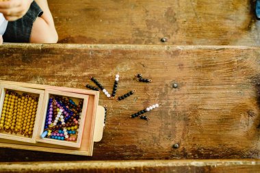 Montessori sınıfta saymak öğrenmek için eğitim materyalleri işleme bir çocuğun elleri.