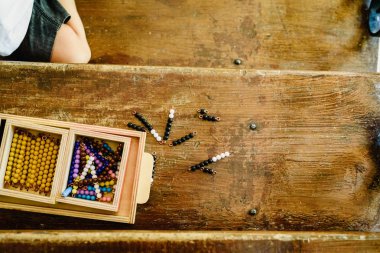 Montessori sınıfta saymak öğrenmek için eğitim materyalleri işleme bir çocuğun elleri.