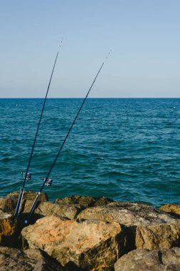 Balıkçılık çubuklar olmadan Balıkçılar deniz kıyısından kayalar için sabit