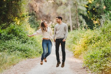 Çift atlama ve yeşil yolun ortasında gülüyor