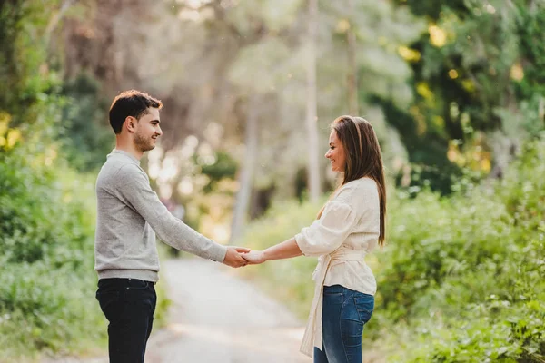 Aşık çift sarılma ve yeşil yolun ortasında gülüyor