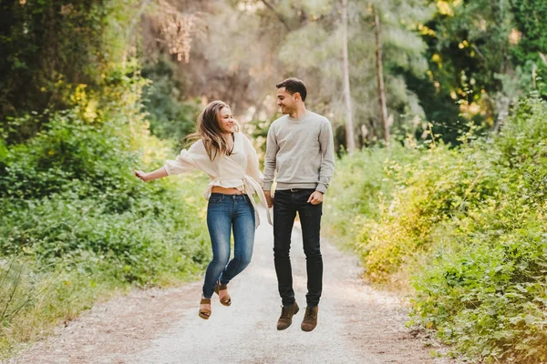 Çift atlama ve yeşil yolun ortasında gülüyor