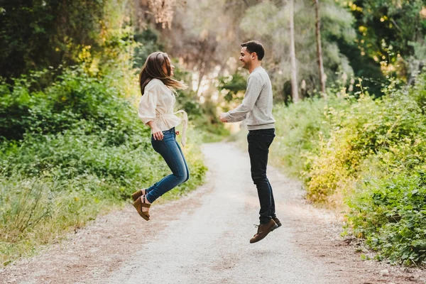 夫妇跳和笑在中间的绿色道路 — 图库照片