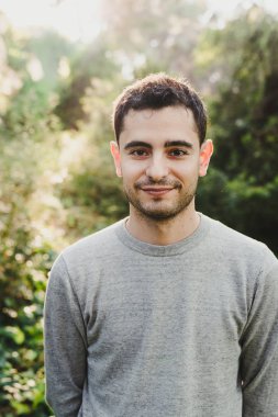 Genç adam doğa ağaçlar, sakin ile poz