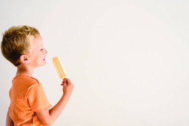 Sevimli çocuk beyaz arka planda bir dondurma yemek.