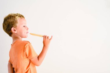 Sevimli çocuk beyaz arka planda bir dondurma yemek.