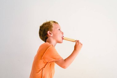 Sevimli çocuk beyaz arka planda bir dondurma yemek.