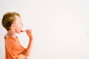 Sevimli çocuk beyaz arka planda bir dondurma yemek.