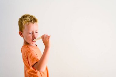 Sevimli çocuk beyaz arka planda bir dondurma yemek.