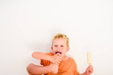 Sevimli çocuk beyaz arka planda bir dondurma yemek.