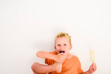 Sevimli çocuk beyaz arka planda bir dondurma yemek.